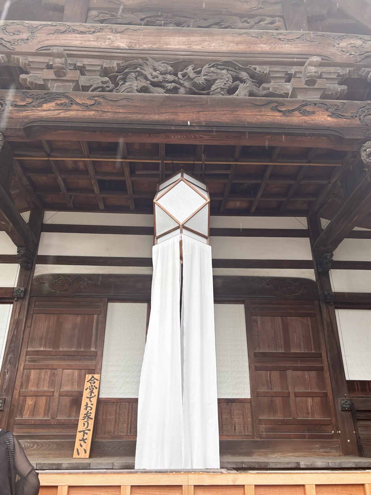 深大寺本堂の軒と「合掌でお参り下さい」の札